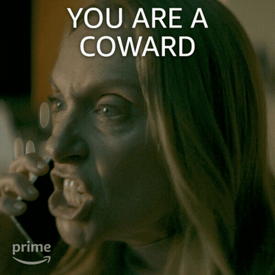 A Woman Talking On A Phone With The Words " You Are A Coward " Written Above Her GIF