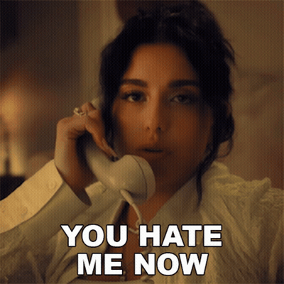 A Woman Talking On A Phone With The Words " You Hate Me Now " Next To Her GIF