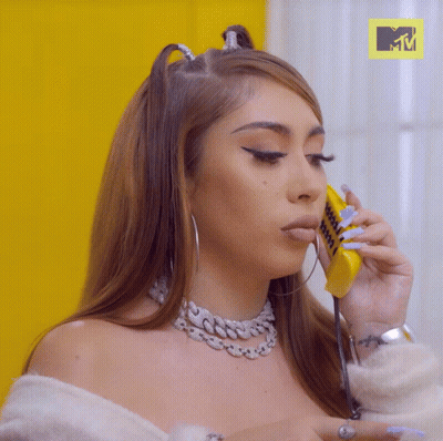 A Woman Talking On A Yellow Phone With A Mtv Logo In The Background GIF