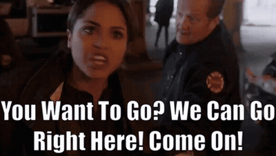 A Woman Talking To A Police Officer With The Words " You Want To Go ? We Can Go Right Here Come On ! " GIF