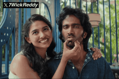 A Woman Touching A Man 'S Face With A 7Wick Reddy Watermark GIF