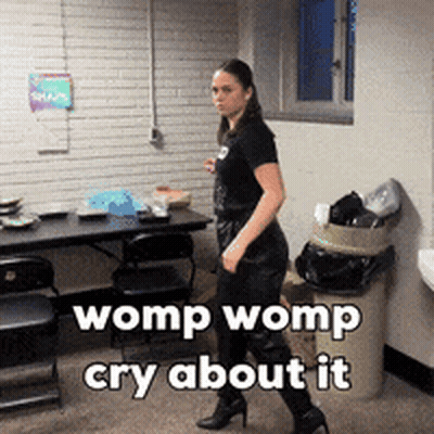 A Woman Walking In A Room With The Words Womp Womp Cry About It GIF