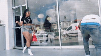A Woman Walking In Front Of A Store With The Number 1441 On The Door GIF