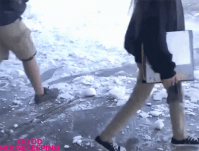 A Woman Walking In The Snow With The Words Good Housekeeping Written On The Bottom GIF