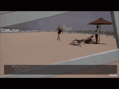 A Woman Walking On A Beach With Hollywood Girls 3 Written On The Bottom GIF