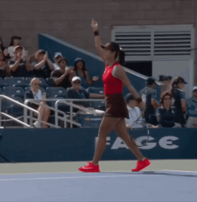 A Woman Walking On A Tennis Court With A Sign That Says Ace GIF