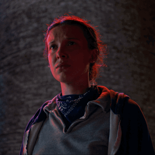 A Woman Wearing A Bandana And A Grey Hoodie Looks At The Camera GIF