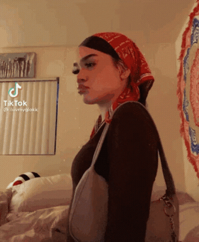 A Woman Wearing A Bandana And A Purse Has A Tiktok Account GIF