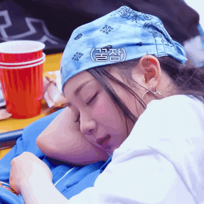 A Woman Wearing A Bandana Is Sleeping On A Man 'S Shoulder GIF