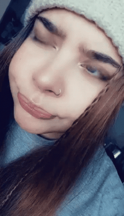 A Woman Wearing A Beanie And A Nose Ring Makes A Funny Face GIF