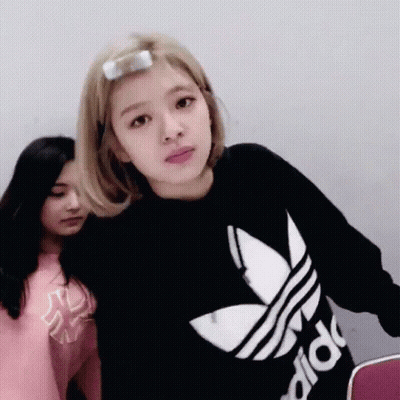 A Woman Wearing A Black Adidas Sweater Looks At The Camera GIF