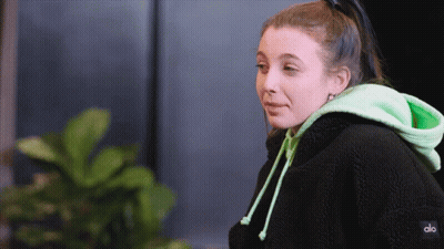 A Woman Wearing A Black And Green Hoodie With The Word Alo On The Back GIF