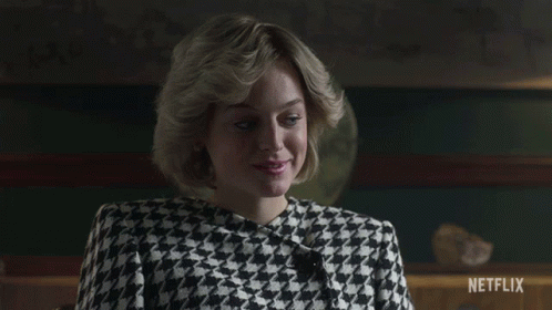 A Woman Wearing A Black And White Houndstooth Jacket Is Sitting In Front Of A Netflix Sign GIF