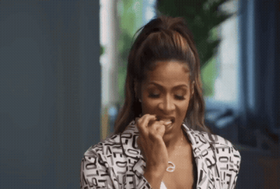 A Woman Wearing A Black And White Jacket With Letters On It GIF