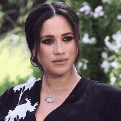 A Woman Wearing A Black And White Shirt And A Necklace GIF