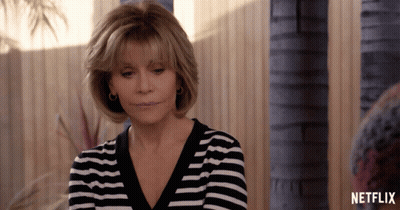 A Woman Wearing A Black And White Striped Shirt With A Netflix Logo On The Bottom GIF