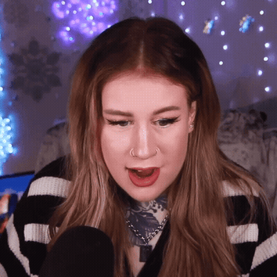 A Woman Wearing A Black And White Striped Sweater Has A Nose Ring GIF