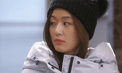 A Woman Wearing A Black Beanie And A White Jacket GIF