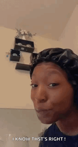 A Woman Wearing A Black Bonnet Is Making A Funny Face . GIF