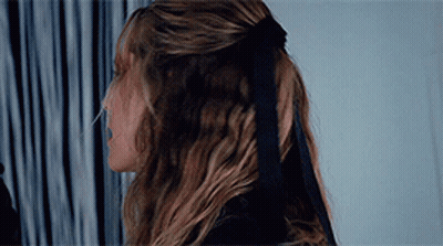 A Woman Wearing A Black Bow In Her Hair GIF