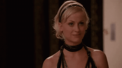 A Woman Wearing A Black Choker And A Headband Is Smiling And Looking At The Camera . GIF