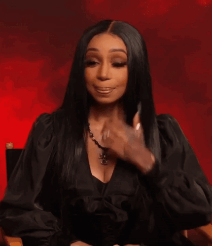 A Woman Wearing A Black Dress And A Cross Necklace GIF