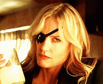A Woman Wearing A Black Eye Patch Holds A Glass GIF