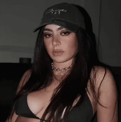 A Woman Wearing A Black Hat And A Black Bikini Top . GIF