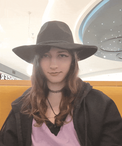 A Woman Wearing A Black Hat And A Purple Shirt GIF