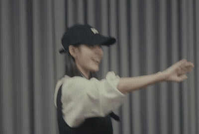 A Woman Wearing A Black Hat And A White Shirt GIF