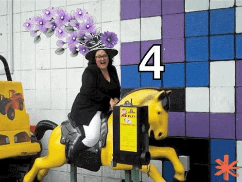 A Woman Wearing A Black Hat Is Riding A Yellow Horse With The Number 4 Above Her GIF
