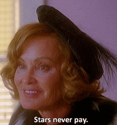 A Woman Wearing A Black Hat With The Words Stars Never Pay Below It GIF