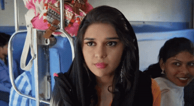 A Woman Wearing A Black Head Scarf Is Sitting On A Train GIF