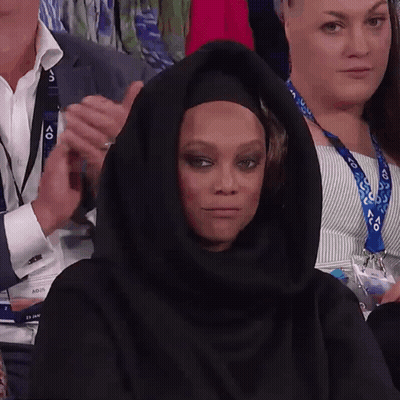 A Woman Wearing A Black Hijab Is Sitting In A Crowd Of People GIF