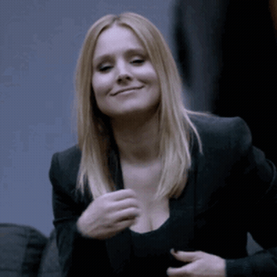 a woman wearing a black jacket and a black top is smiling