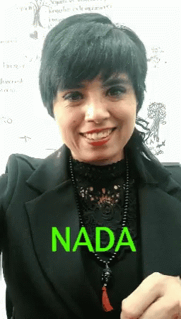 A Woman Wearing A Black Jacket And A Necklace With The Word Nada Written On It GIF