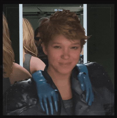 A Woman Wearing A Black Jacket And Blue Gloves Looks At The Camera With The Number 85 On The Screen GIF