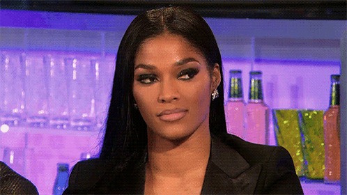 A Woman Wearing A Black Jacket And Earrings Is Making A Funny Face GIF