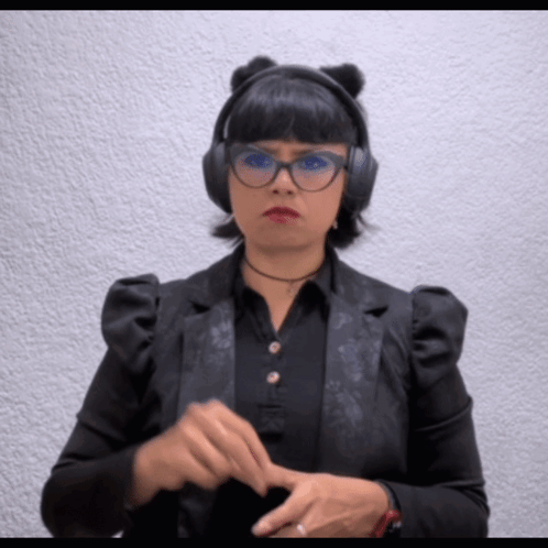 A Woman Wearing A Black Jacket And Headphones Is Making A Funny Face GIF