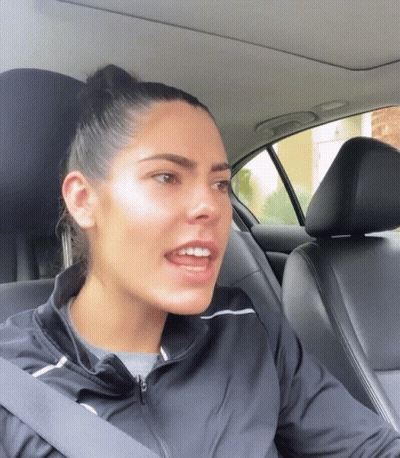 A Woman Wearing A Black Jacket Is Sitting In A Car GIF