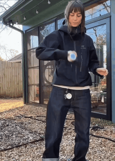 A Woman Wearing A Black Jacket That Says Arcteryx GIF