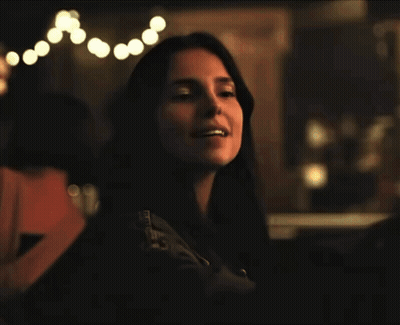 A Woman Wearing A Black Jacket With The Word Converse On The Sleeves GIF
