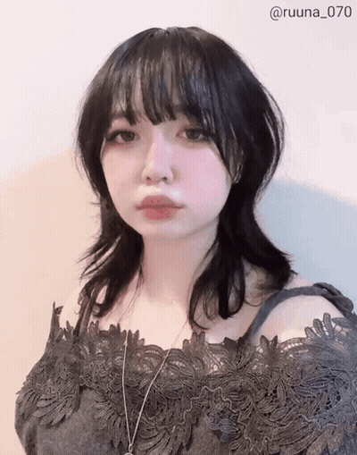 A Woman Wearing A Black Lace Off The Shoulder Top And A Necklace With The Number 070 On The Bottom GIF