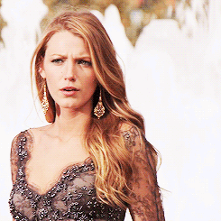A Woman Wearing A Black Lace Top And Earrings GIF