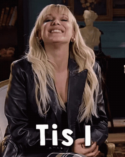 A Woman Wearing A Black Leather Jacket Is Smiling And Says Tis I . GIF