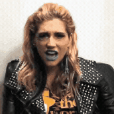 A Woman Wearing A Black Leather Jacket With Studs Is Making A Funny Face GIF