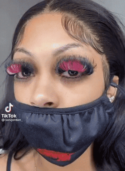 A Woman Wearing A Black Mask With A Red Lip On It . GIF