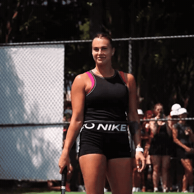 A Woman Wearing A Black Nike Top And Shorts Holds A Tennis Racket GIF