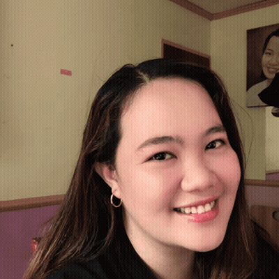 A Woman Wearing A Black Shirt And Hoop Earrings Smiles GIF