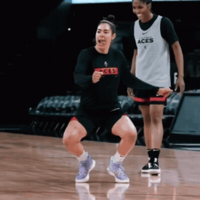 A Woman Wearing A Black Shirt That Says Aces On It GIF